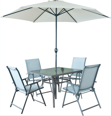 Tavolo da pranzo pieno e sedie all'aperto d'acciaio messi con il parasole di Sun